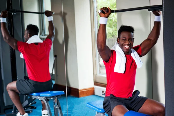 Confiado chico africano joven haciendo ejercicio en el gimnasio — Foto de Stock