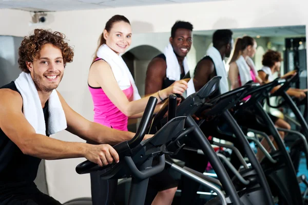 Grupp vänner cykling i gym — Stockfoto