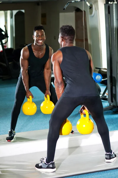 Giovane uomo muscoloso che lavora con kettlebell — Foto Stock