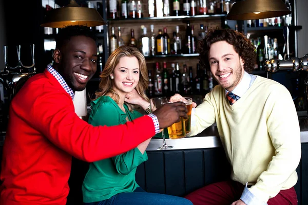 Tres amigos en el bar disfrutando de la cerveza — Foto de Stock