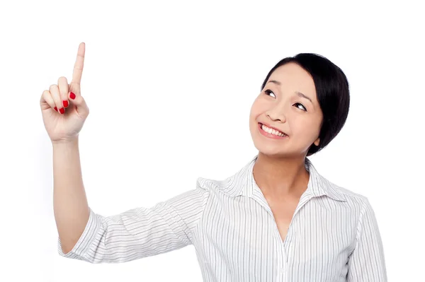 Sonriente chica bonita mirando y apuntando hacia arriba — Foto de Stock