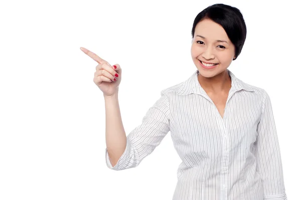 Happy young girl pointing at copy space area — Stock Photo, Image