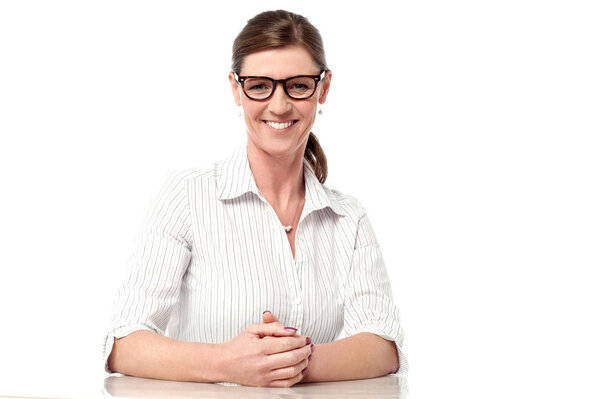 Профессиональная женщина за столом, улыбающаяся
