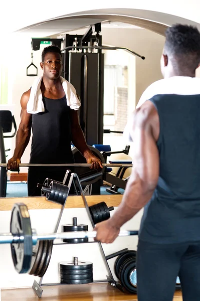 Young bodybuilder lifting the barbell — Stock Photo, Image