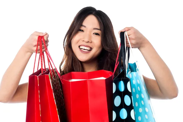 Pretty young chinese girl holding shopping bags — Stock Photo, Image