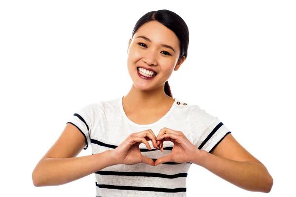 Bella donna che fa simbolo del cuore con le mani Foto Stock