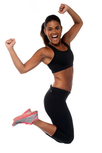Woman in sportswear jumping with joy Stock Photo