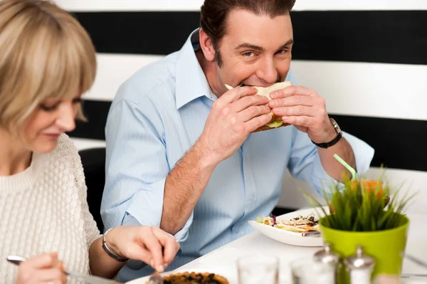 Pohledný muž se těší vynikající sendvič — Stock fotografie