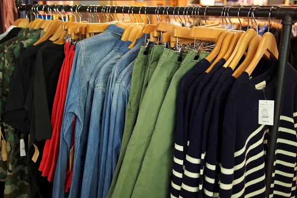 Módní oblečení na ramínkách v obchodě — Stock fotografie