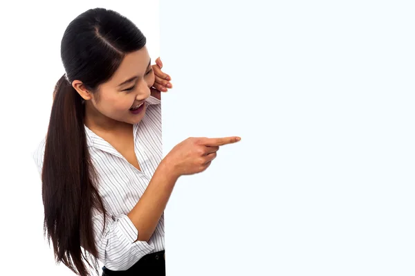 Saleswoman pointing towards ad on billboard — Stock Photo, Image