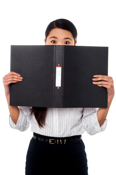 Kvinna gömmer sig hennes ansikte med en business-fil — Stockfoto