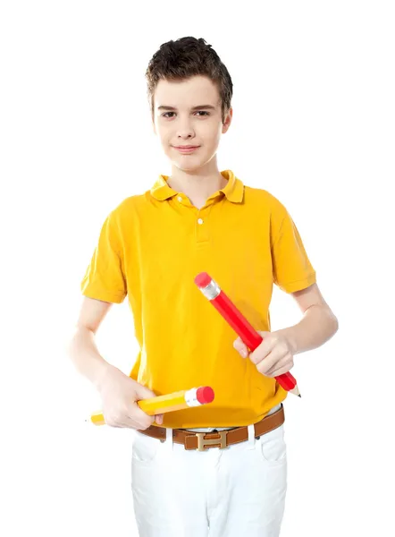 Niño sosteniendo dos grandes lápices de colores —  Fotos de Stock