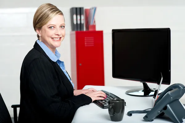 Lachende vrouwelijke secretaris op het werk — Stockfoto