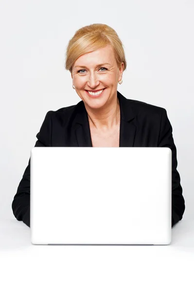 Изолированная улыбающаяся корпоративная леди, работающая над ноутбуком — стоковое фото