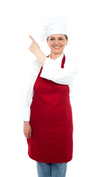 Baker woman pointing towards copy space area — Stock Photo, Image