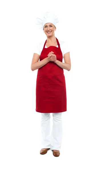 Atrakcyjna kobieta kucharz w czerwony fartuch i czapkę — Zdjęcie stockowe