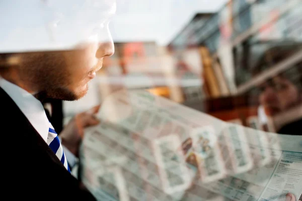 Male passenger reading newspaper in taxi — Stock Photo, Image