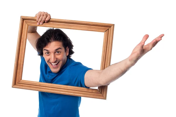 Emocionado hombre sosteniendo marco de imagen — Foto de Stock
