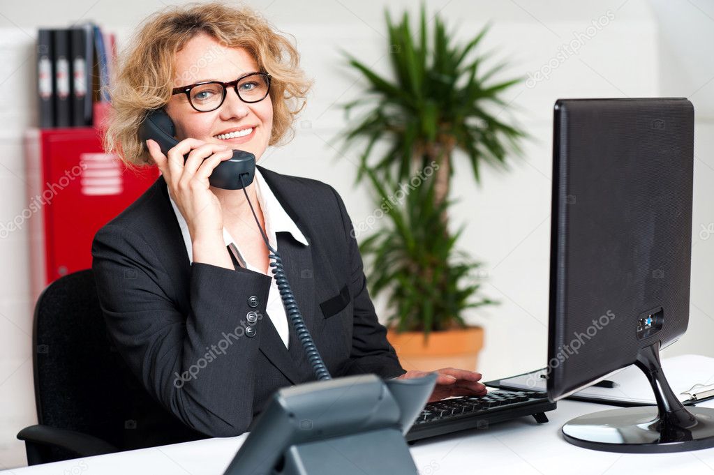 Happy front desk lady attending clients call