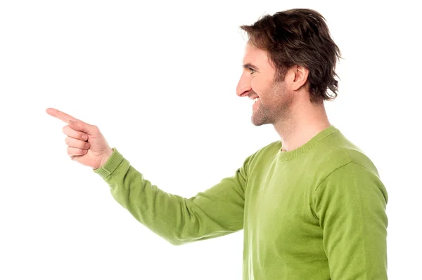 Casual young guy pointing away — Stock Photo, Image