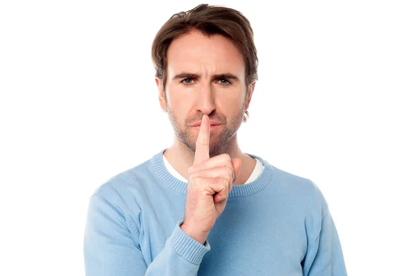 Young male holds finger on his lips — Stock Photo, Image