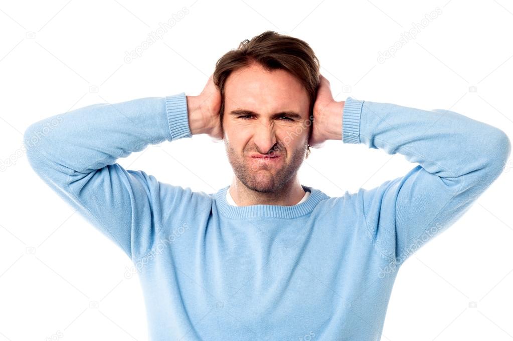 Irritated man blocking his ears
