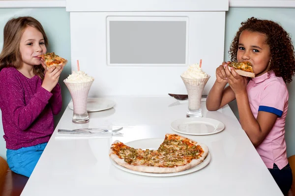 Κοριτσάκια, απολαμβάνοντας την πίτσα σε ένα εστιατόριο — Φωτογραφία Αρχείου