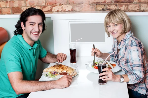 Joven pareja sonriente disfrutando del almuerzo — Foto de Stock