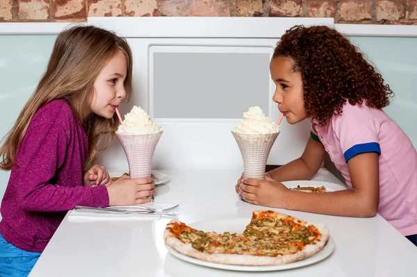 Young girls sipping strawberry shake — Stock Photo, Image