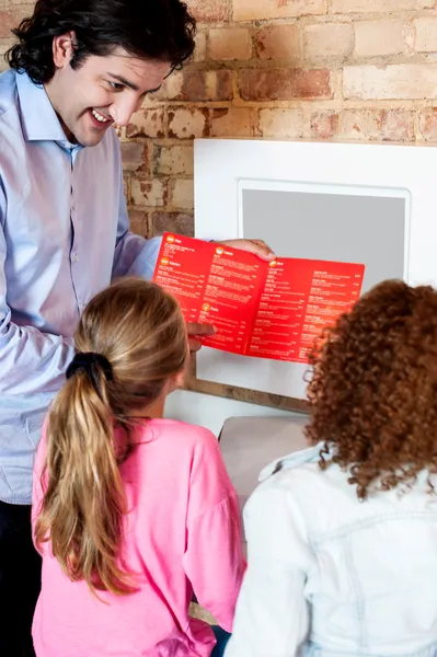 Άνθρωπος δείχνει κόρες πώς να παραγγείλετε πίτσα σε απευθείας σύνδεση — Φωτογραφία Αρχείου