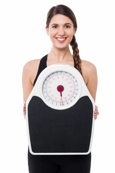 Young girl holding weighing machine — Stock Photo, Image