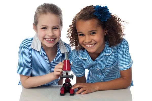 Joyeuses jeunes écolières avec microscope — Photo