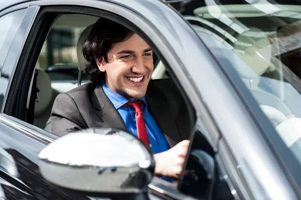 Handsome businessman driving a luxurious car — Stock Photo, Image