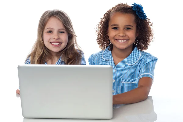 Two cute little school girls with laptop — Stock Photo, Image