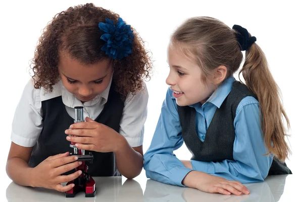 Duas meninas bonitas da escola com microscópio — Fotografia de Stock