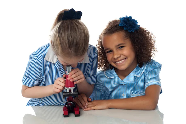 Meninas da escola usando um microscópio no laboratório — Fotografia de Stock