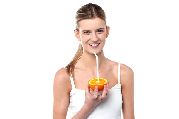 Girl sipping orange juice through straw — Stock Photo, Image