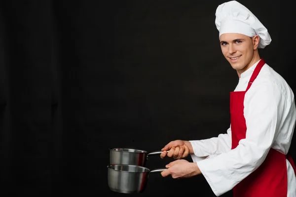 Jonge mannelijke chef-kok bezit leeg vaartuigen — Stockfoto