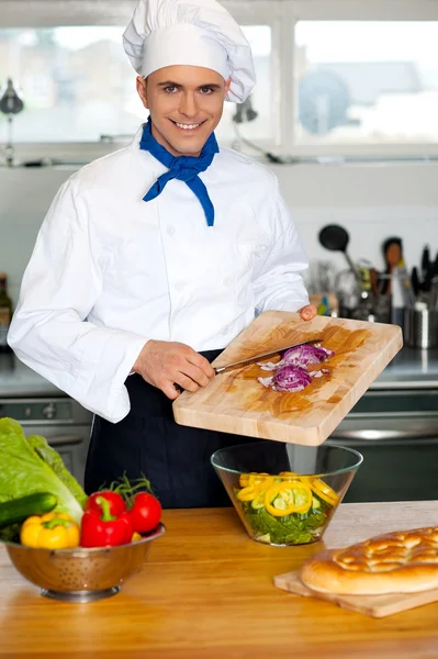 Chef colocando legumes em uma tigela — Fotografia de Stock