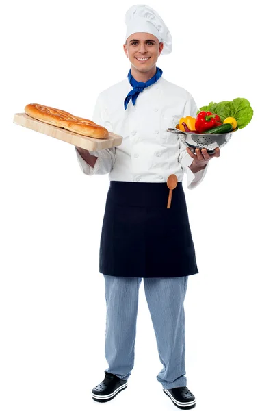 Chef sosteniendo verduras frescas y pan — Foto de Stock