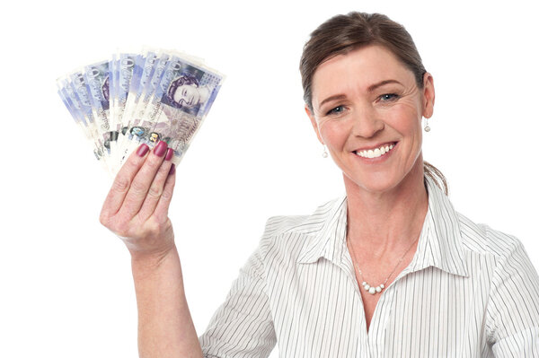 Businesswoman holding fan of currency notes