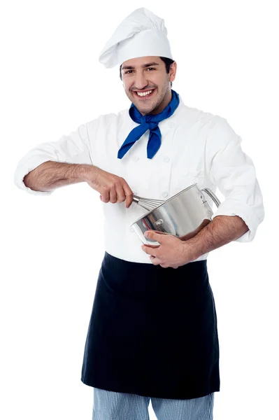 Ervaren mannelijke chef-kok met behulp van ei klopper — Stockfoto