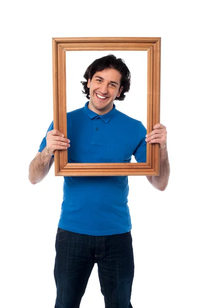 Hombre sosteniendo marco de madera — Foto de Stock