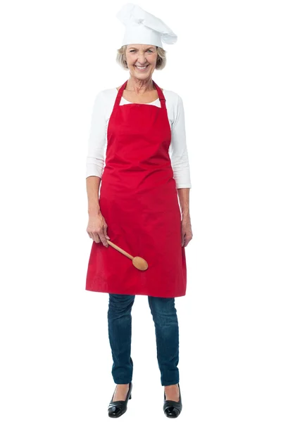 Kaşık ile neşeli üst düzey kadın aşçı — Stok fotoğraf