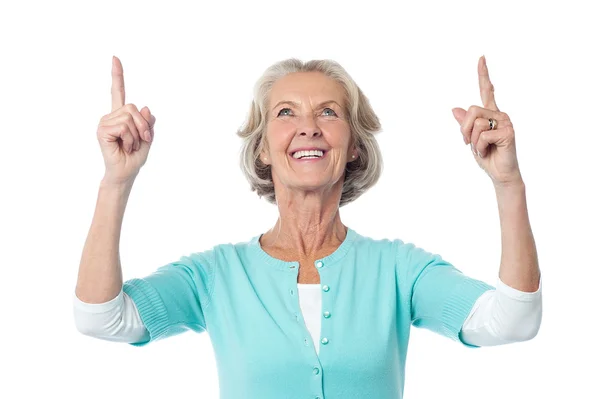 Beautiful senior lady pointing upwards — Stock Photo, Image