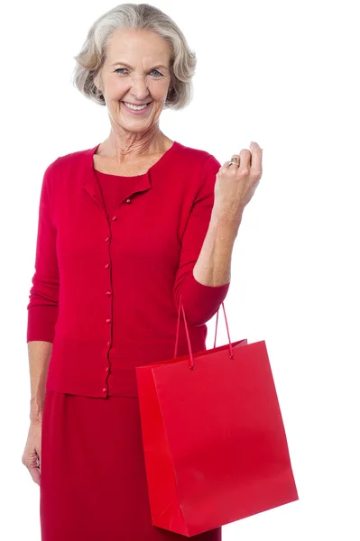 Senior woman holding red shopping bag — Stock Photo, Image