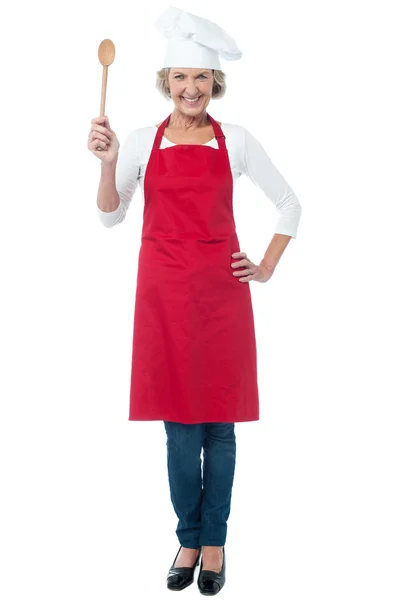 Happy aged chef holding wooden spoon — Stock Photo, Image