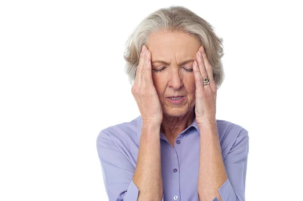Velha senhora sofrendo de dor de cabeça — Fotografia de Stock