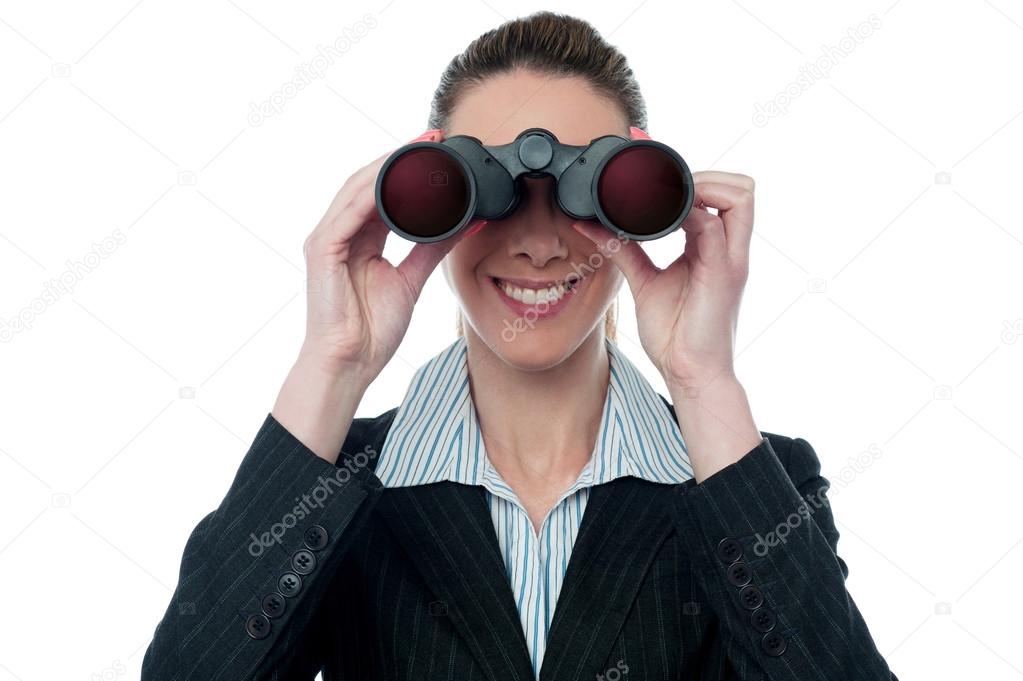 Businesswoman looking through binocular