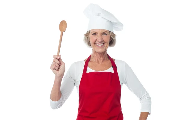 Happy aged chef holding wooden spoon — Stock Photo, Image